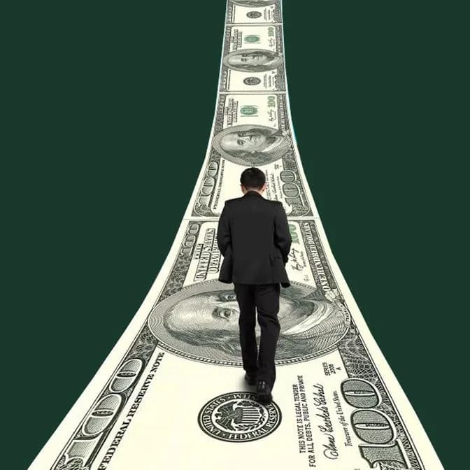 Man in a suit walking along a road made of banknotes